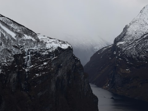 Snow-covered cliffs falling into a narrow fjord
